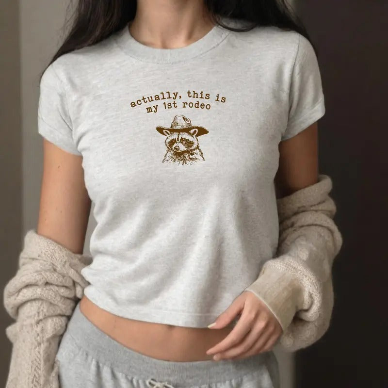 Actually This Is My First Rodeo Baby Tee - Y2K-style graphic tee with fun rodeo twist, perfect for casual wear.