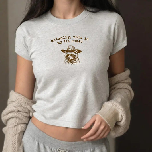 Actually This Is My First Rodeo Baby Tee - Y2K-style graphic tee with fun rodeo twist, perfect for casual wear.
